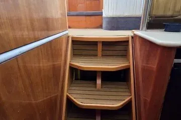 Slide: The Image of Interior stairs of a 1998 Viking Princess 56 Sport Cruiser, featuring wooden steps and paneling. - 26