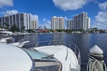 Slide: The Image of 1998 Viking Princess 56 Sport Cruiser docked near waterfront skyscrapers under blue sky. - 6