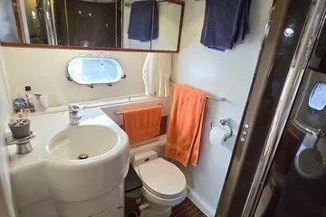 Slide: The Image of Bathroom interior of 1998 Viking Princess 56 Sport Cruiser with sink, toilet, and towels. - 33