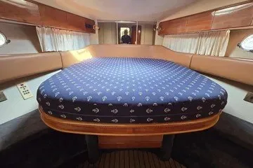 Slide: The Image of 1998 Viking Princess 56 Sport Cruiser cabin with a cozy bed and nautical-themed decor. - 34