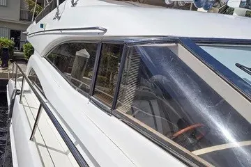 Slide: The Image of 1998 Viking Princess 56 Sport Cruiser, sleek white exterior, docked in marina. - 5