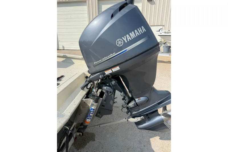 Slide: The Image of 2013 Xpress H20B Bay boat with Yamaha outboard motor in a garage setting. - 18