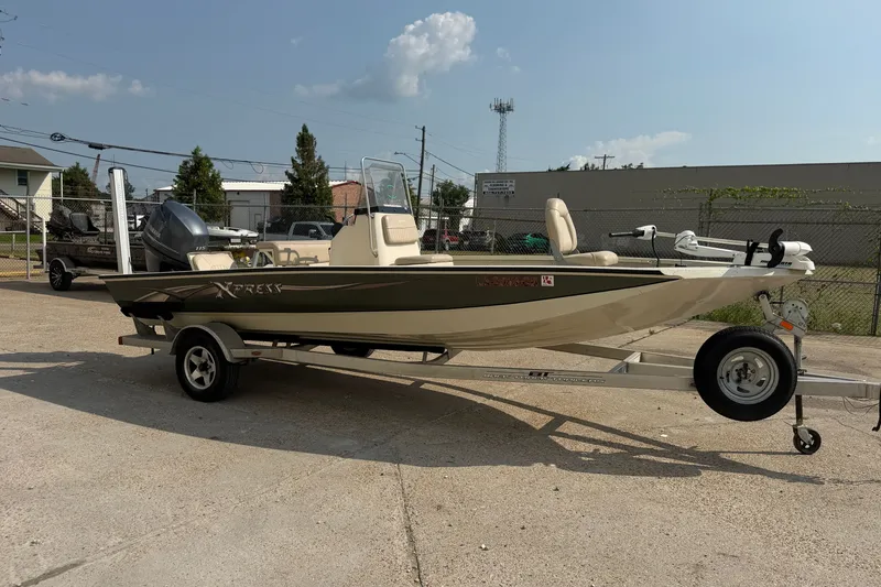 The Image of 2013 Xpress H20B Bay boat on trailer, parked outdoors under clear sky. - 0
