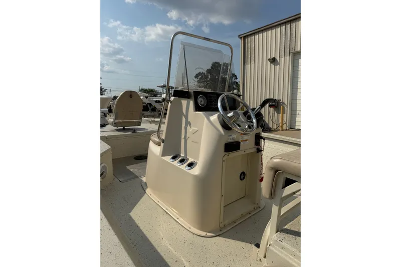 Slide: The Image of 2013 Xpress H20B Bay boat console with steering wheel and controls, outdoors. - 15