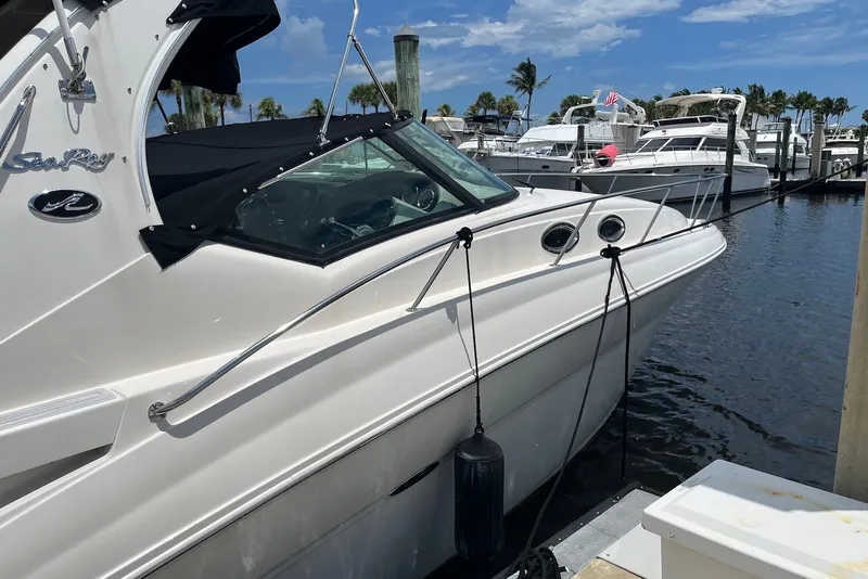 Slide: The Image of 2003 Sea Ray Sundancer 320 docked at marina, clear sky, palm trees in background. - 1
