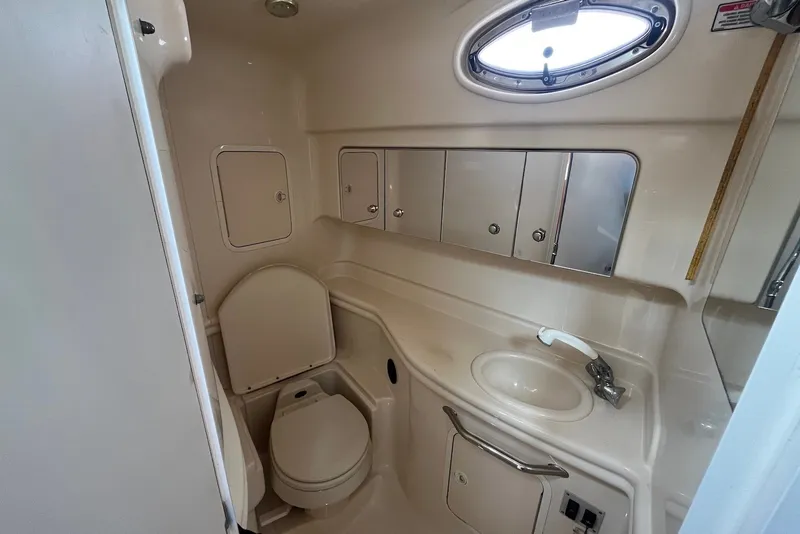 Slide: The Image of 2003 Sea Ray Sundancer 320 bathroom with sink, toilet, and storage cabinets. - 11