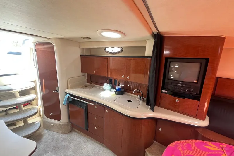 Slide: The Image of 2003 Sea Ray Sundancer 320 cabin interior with kitchenette and entertainment system. - 8