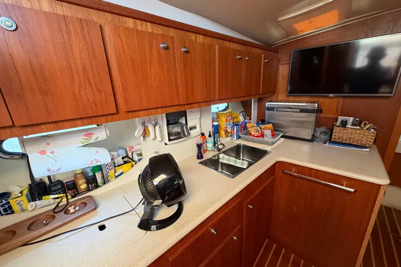 Slide: The Image of 2001 Tiara 35 Express yacht kitchen with wooden cabinets and modern appliances. - 12