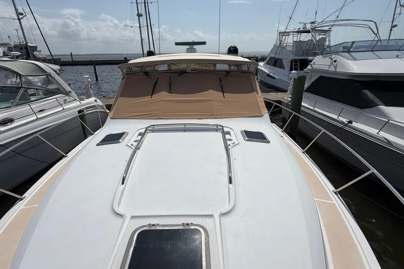 Slide: The Image of 2001 Tiara 35 Express yacht docked at marina, featuring sleek design and beige canopy. - 7