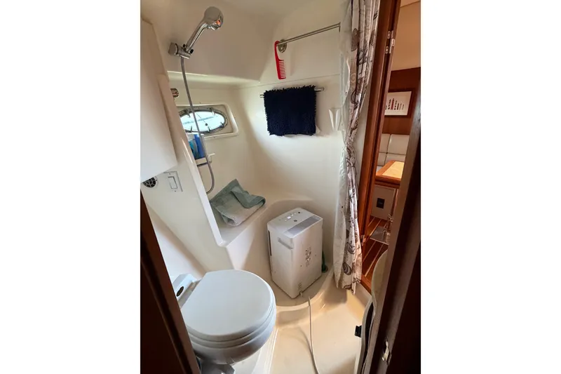Slide: The Image of Compact bathroom in a 2001 Tiara 35 Express boat, featuring a toilet and shower. - 17