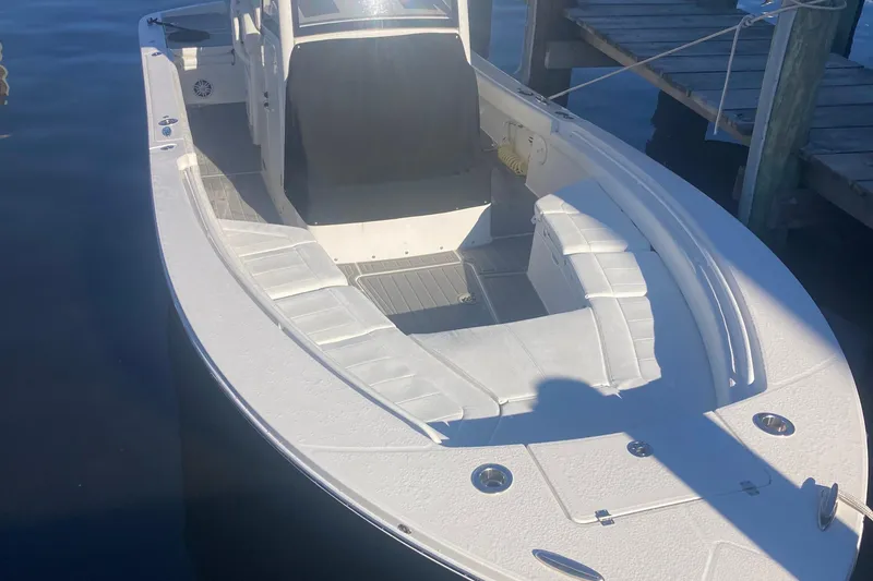 Slide: The Image of 2022 Regulator 26XO boat docked, featuring spacious seating and sleek design. - 8