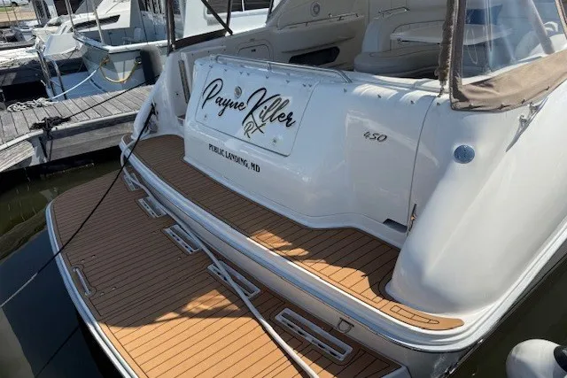 Slide: The Image of 1996 Sea Ray 450 Sundancer docked, featuring teak swim platform and custom nameplate. - 10