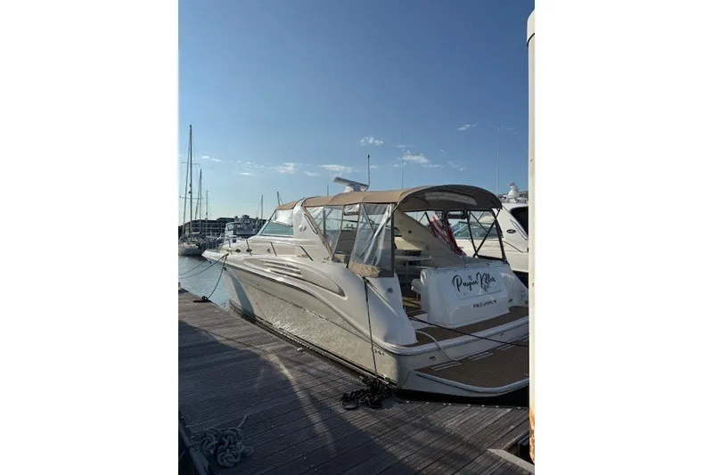 Slide: The Image of 1996 Sea Ray 450 Sundancer yacht docked at marina under clear blue sky. - 3