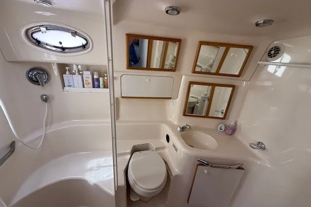 Slide: The Image of Bathroom interior of 1996 Sea Ray 450 Sundancer yacht, featuring shower, sink, and mirrors. - 32