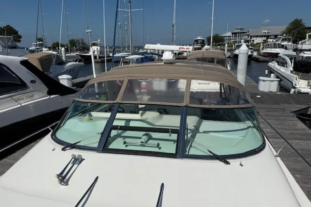 Slide: The Image of 1996 Sea Ray 450 Sundancer docked at a marina, showcasing sleek design and spacious deck. - 4