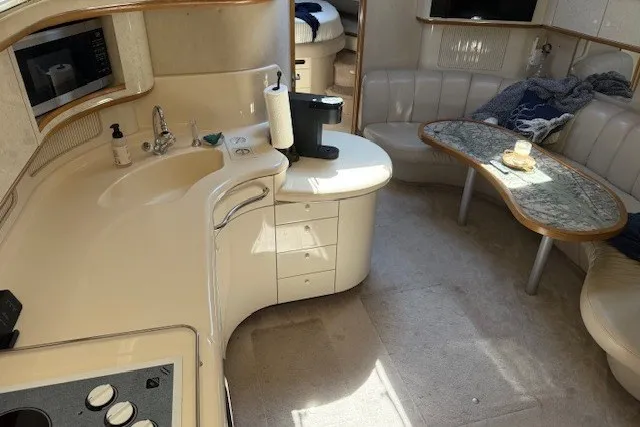 Slide: The Image of Interior of a 1996 Sea Ray 450 Sundancer yacht with kitchen and seating area. - 25