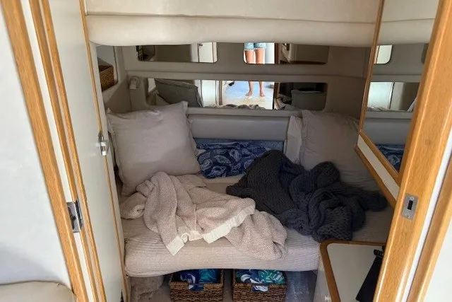 Slide: The Image of Cozy cabin interior of a 1996 Sea Ray 450 Sundancer with bedding and pillows. - 34