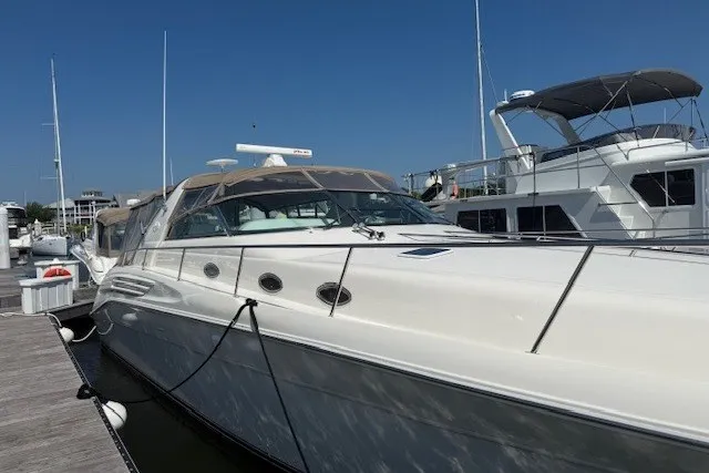 Slide: The Image of 1996 Sea Ray 450 Sundancer yacht docked at marina under clear blue sky. - 1