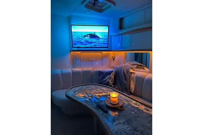 Slide: The Image of Cozy interior of 1996 Sea Ray 450 Sundancer with candlelit table and ocean-themed decor. - 15