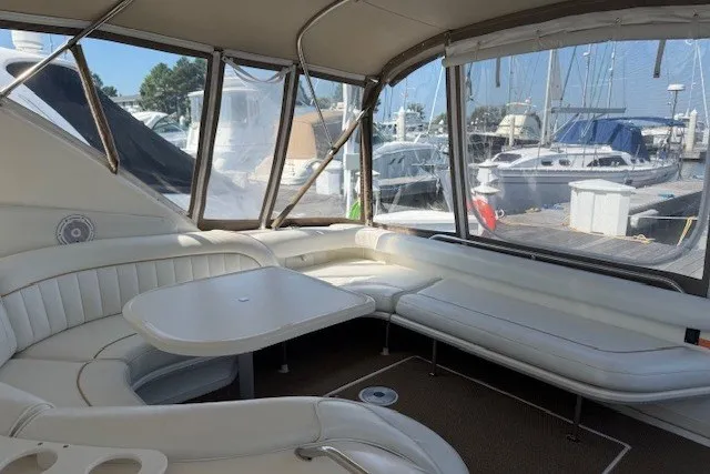 Slide: The Image of Interior of 1996 Sea Ray 450 Sundancer yacht with white seating and table. - 13