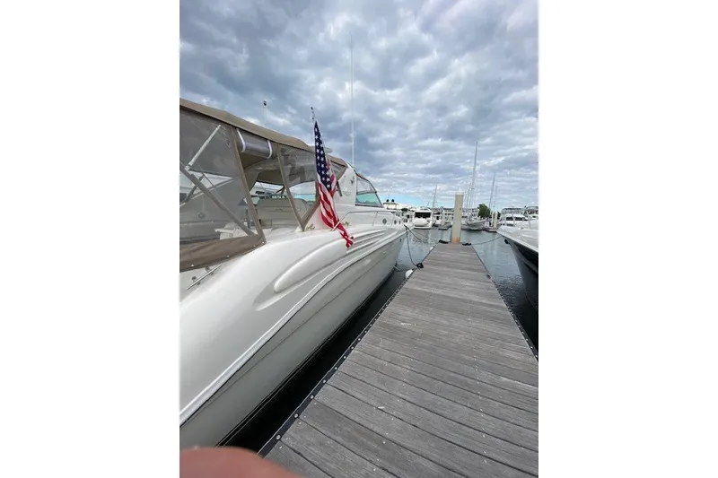 Slide: The Image of 1996 Sea Ray 450 Sundancer yacht docked at marina under cloudy sky. - 5