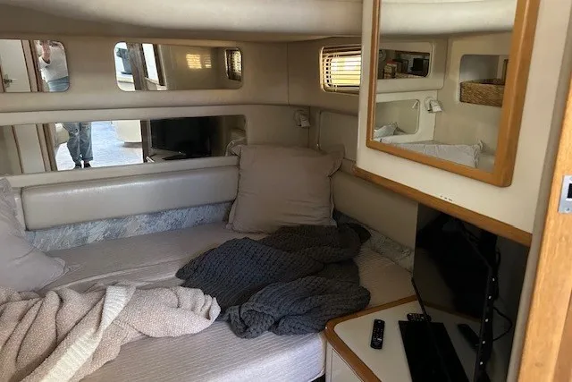 Slide: The Image of Cozy interior cabin of a 1996 Sea Ray 450 Sundancer with bed, TV, and mirror. - 19