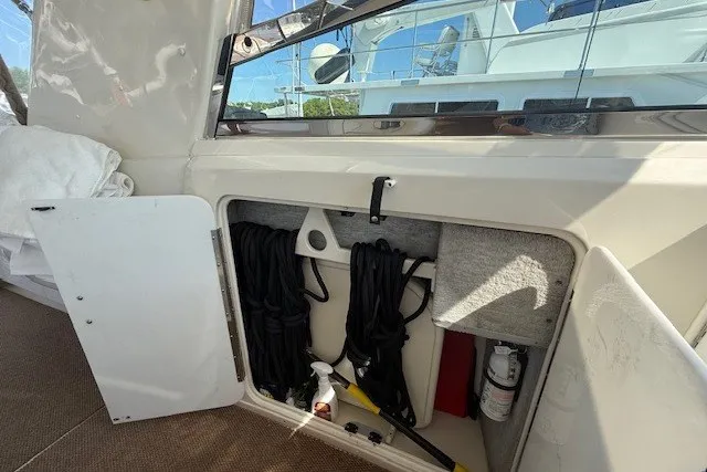 Slide: The Image of Storage compartment on a 1996 Sea Ray 450 Sundancer boat, featuring ropes and safety equipment. - 22