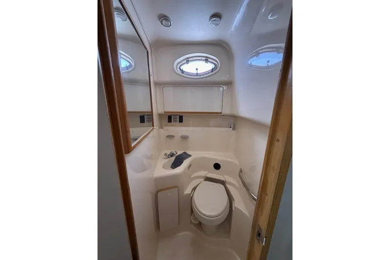 Slide: The Image of Bathroom interior of 1996 Sea Ray 450 Sundancer yacht, featuring compact design and porthole window. - 35
