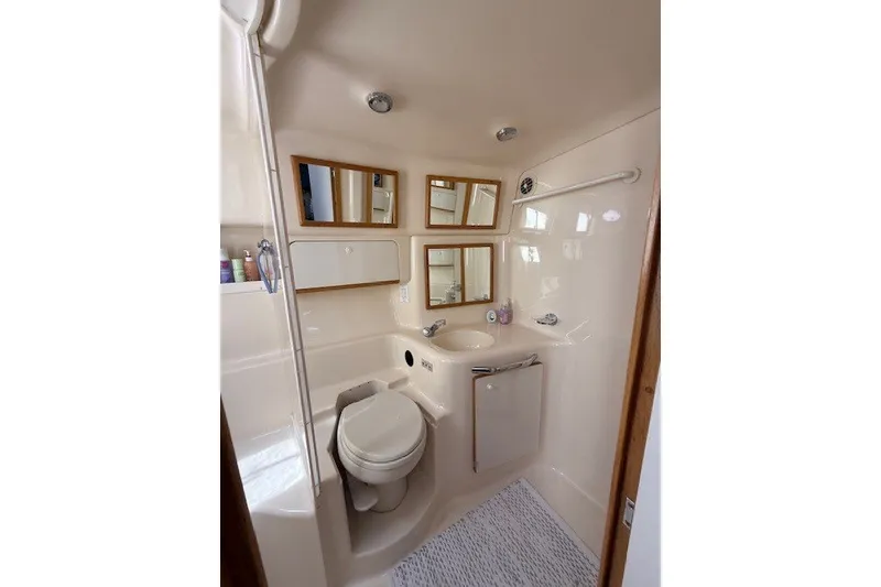 Slide: The Image of Bathroom interior of 1996 Sea Ray 450 Sundancer yacht, featuring mirrors and compact design. - 37