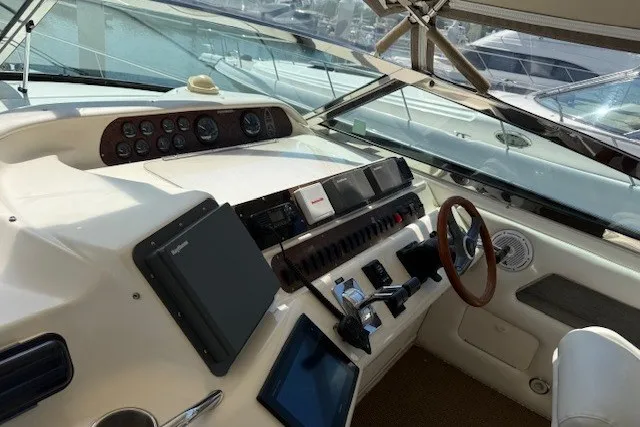 Slide: The Image of Helm of 1996 Sea Ray 450 Sundancer with modern navigation equipment and wooden steering wheel. - 20