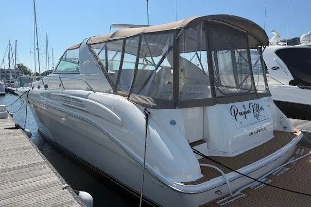 Slide: The Image of 1996 Sea Ray 450 Sundancer yacht docked at marina, featuring sleek design and covered cockpit. - 3