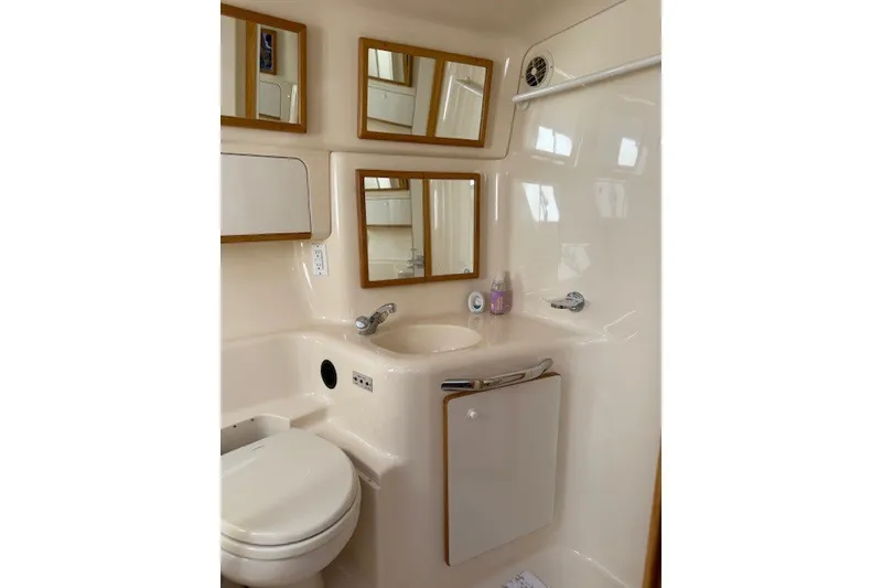 Slide: The Image of Bathroom interior of 1996 Sea Ray 450 Sundancer yacht, featuring sink, toilet, and mirrors. - 36