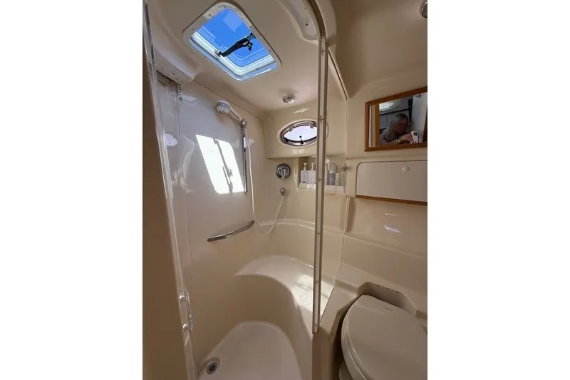 Slide: The Image of Bathroom interior of 1996 Sea Ray 450 Sundancer yacht, featuring shower and porthole window. - 39