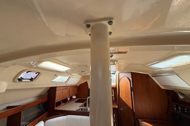 Slide: The Image of Interior of 1989 Hunter 30 sailboat, featuring wood cabinetry and natural light. - 30