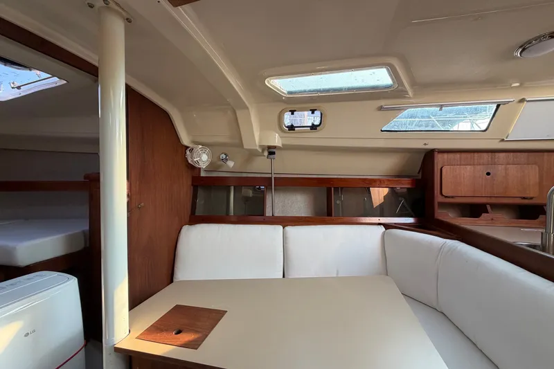 Slide: The Image of Interior of 1989 Hunter 30 sailboat with white seating and wooden accents. - 33