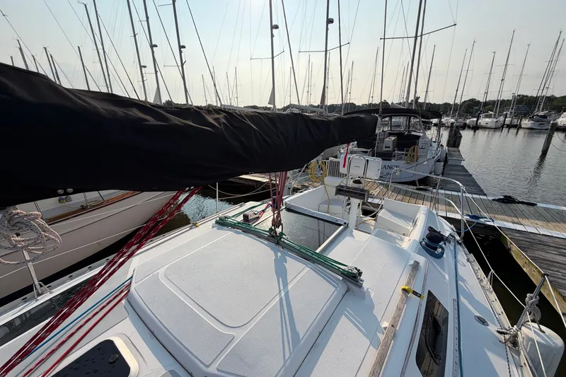 Slide: The Image of 1989 Hunter 30 sailboat docked at marina, surrounded by other boats. - 13