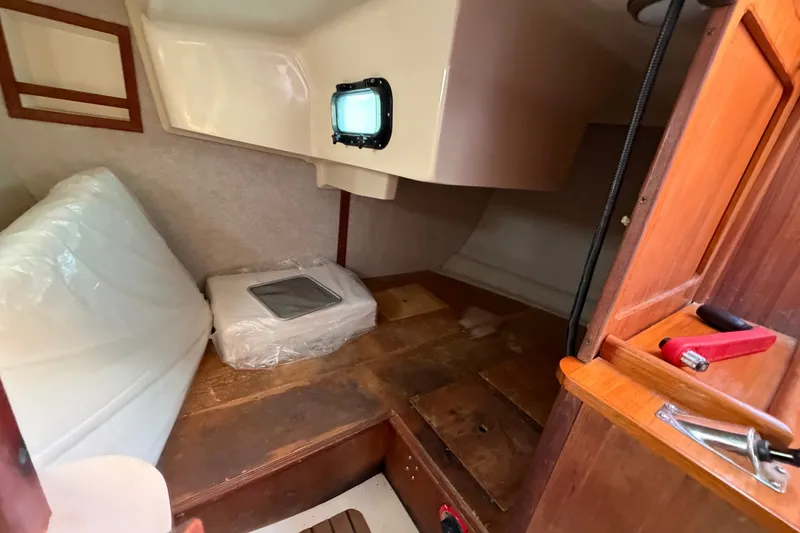 Slide: The Image of Interior cabin of a 1989 Hunter 30 sailboat with wooden and white accents. - 17