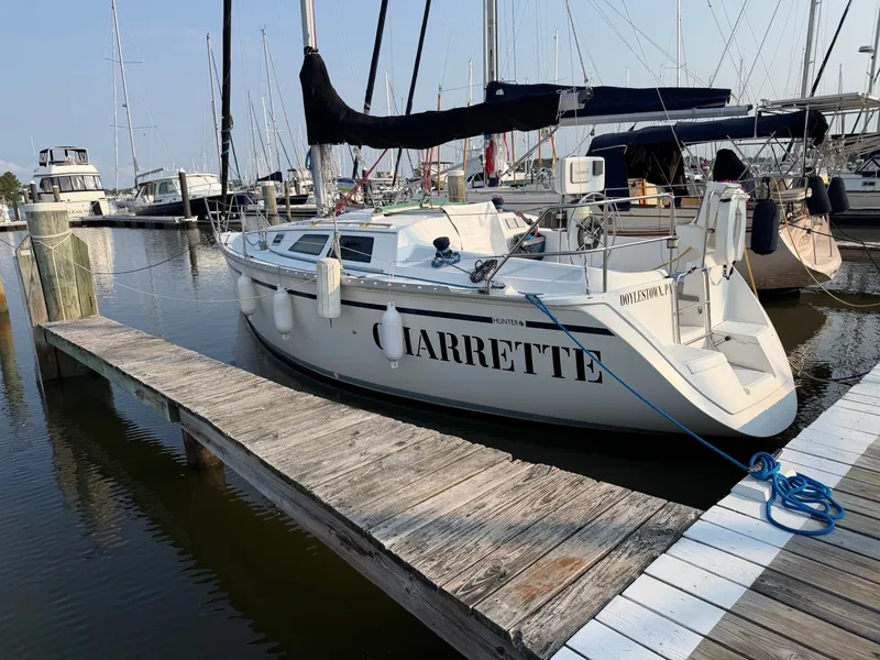 The Image of A 1989 Hunter 30 sailboat docked at a wooden pier in a marina. - 0