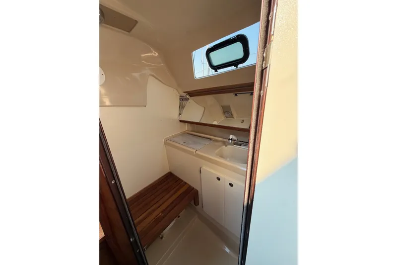 Slide: The Image of Interior of 1989 Hunter 30 sailboat featuring compact sink and wooden bench. - 24