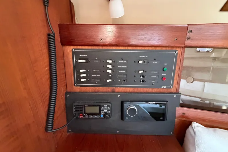 Slide: The Image of Control panel inside a 1989 Hunter 30 sailboat, featuring switches and communication equipment. - 26