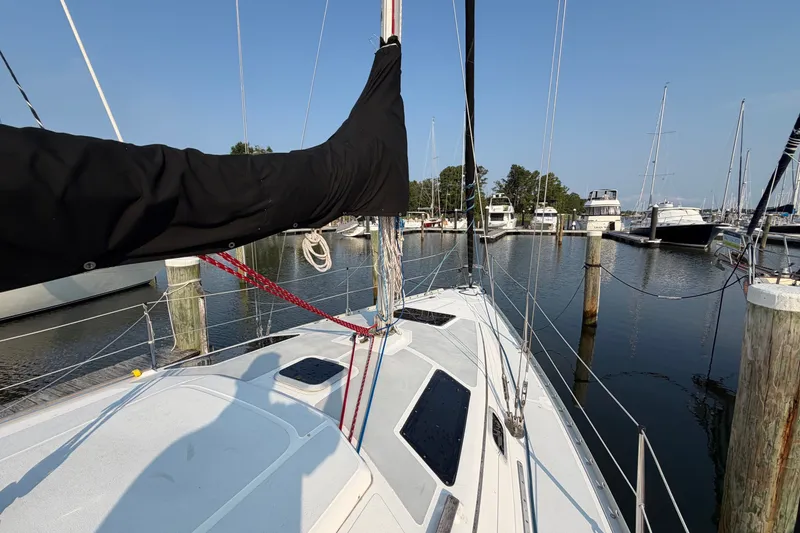 Slide: The Image of 1989 Hunter 30 sailboat docked in a marina, surrounded by other boats. - 10