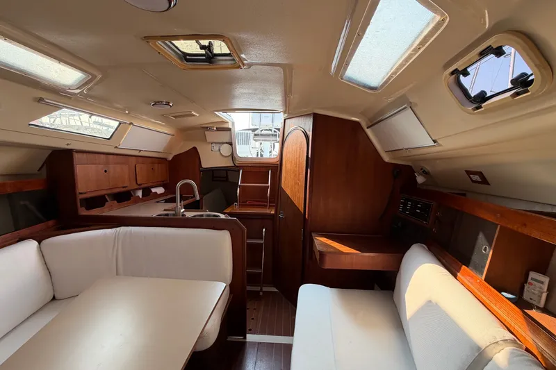 Slide: The Image of Interior of a 1989 Hunter 30 sailboat with wood accents and white seating. - 31