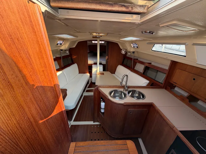Slide: The Image of Interior of a 1989 Hunter 30 sailboat with wood finishes and white upholstery. - 2