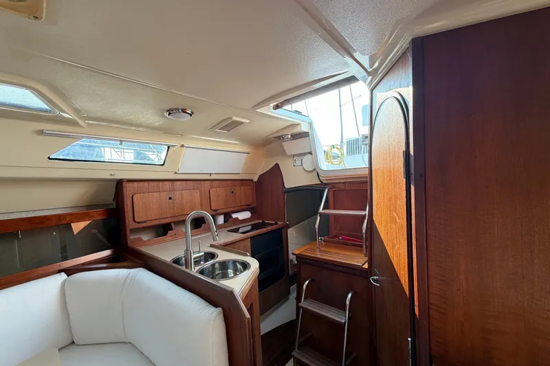 Slide: The Image of Interior of 1989 Hunter 30 sailboat with wood cabinetry and compact kitchen area. - 32