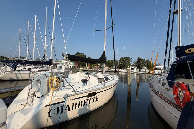 Slide: The Image of 1989 Hunter 30 sailboat docked in a marina, surrounded by other boats. - 4