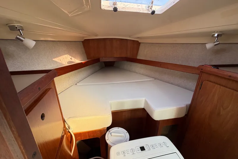 Slide: The Image of Interior cabin of a 1989 Hunter 30 sailboat with wooden finish and white cushions. - 29