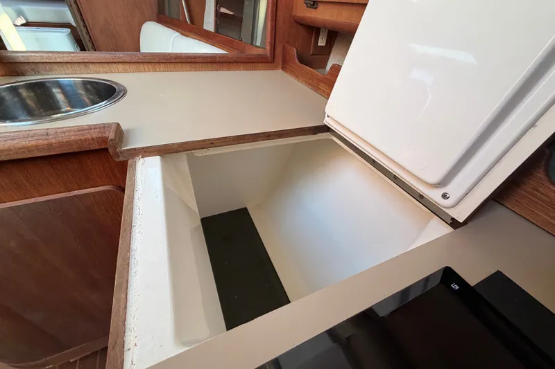 Slide: The Image of Interior of 1989 Hunter 30 sailboat galley with open storage compartment and sink. - 21
