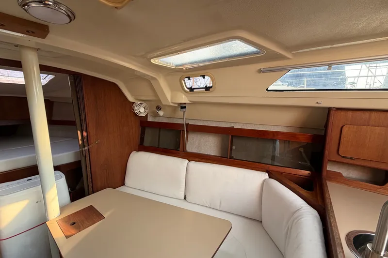 Slide: The Image of Interior of a 1989 Hunter 30 sailboat with cozy seating and wooden accents. - 28