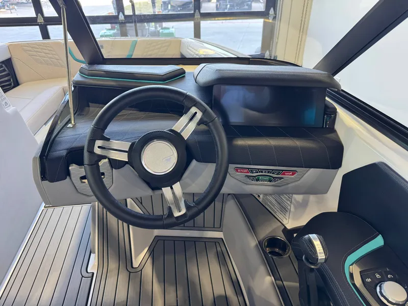 Slide: The Image of The image shows the cockpit of a 2024 Nautique Super Air Nautique G23 with a modern steering wheel and large display. - 27