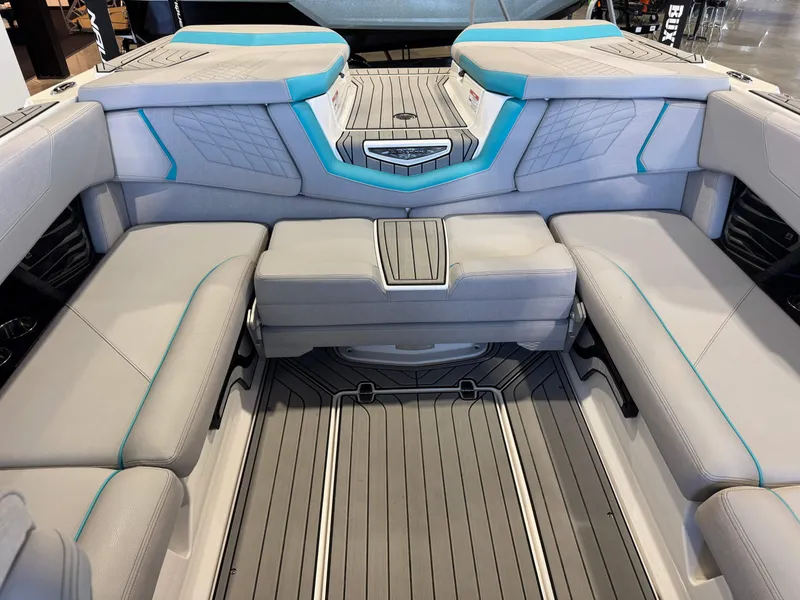 Slide: The Image of The image shows the interior of a 2024 Nautique Super Air Nautique G23 with gray and blue upholstery. - 28